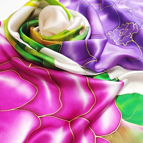Fular de seda para mujer pintado a mano con flores malvas y rosas con hojas lanceoladas en tonos verdes.